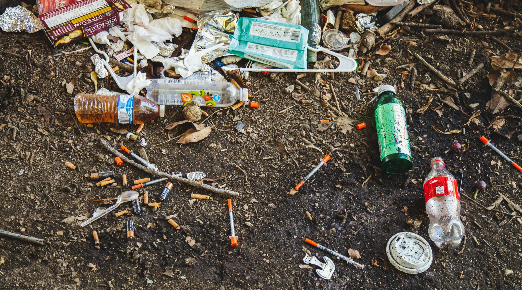 syringes and old bottles laying on the ground