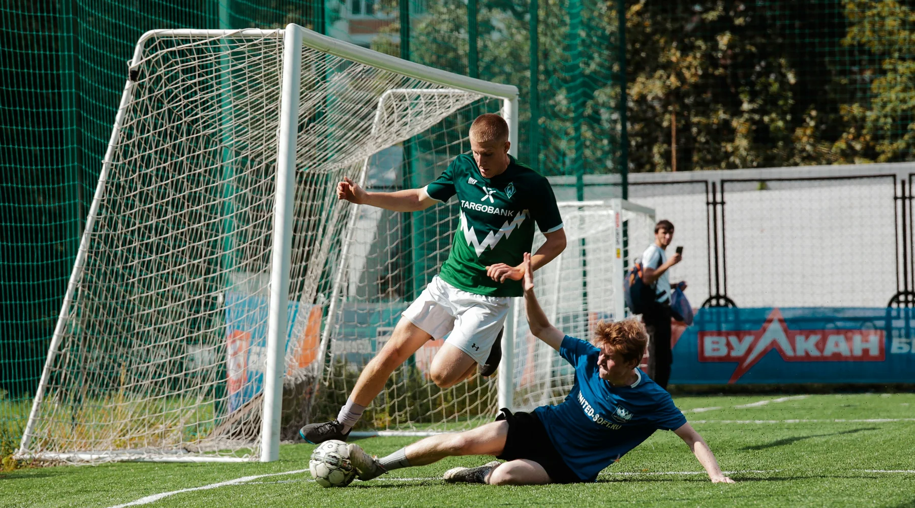 man-in-blue-and-white-soccer-jersey-kicking-ball-on-green-grass-field-during-daytime