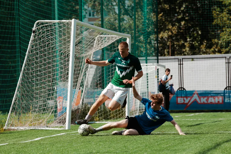 man-in-blue-and-white-soccer-jersey-kicking-ball-on-green-grass-field-during-daytime